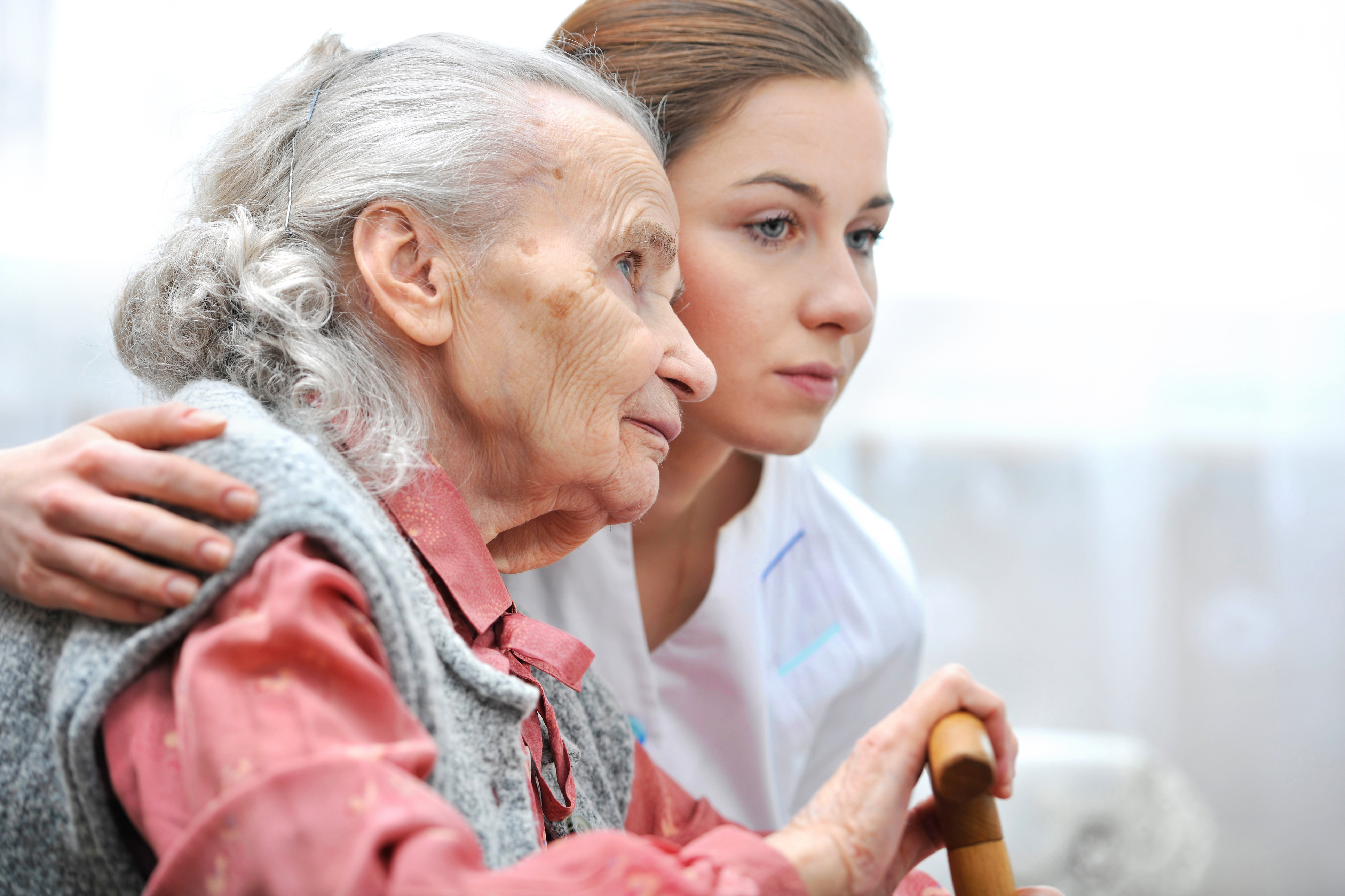 photo of elderly woman assisted by a caretaker
