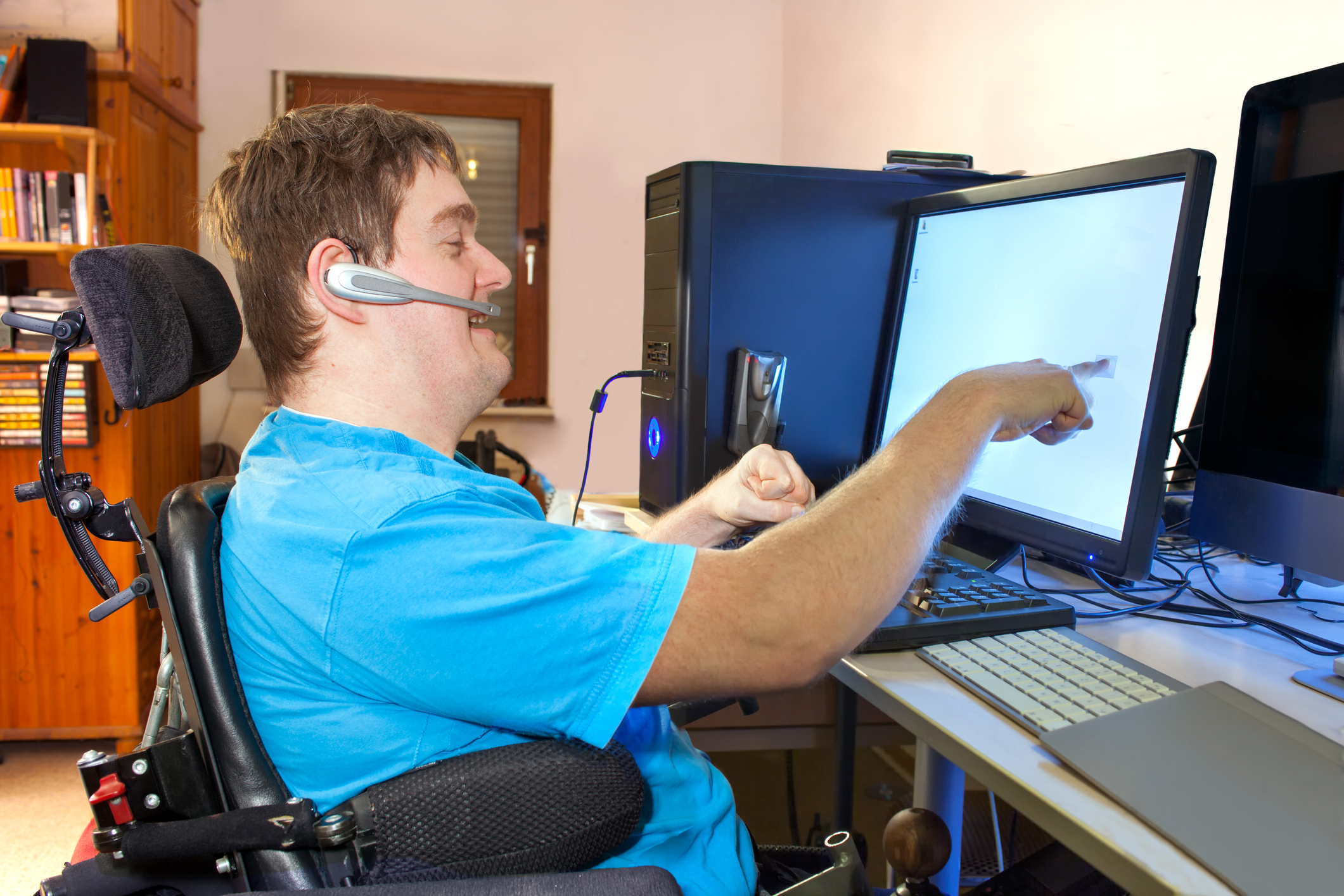 photo of a disabled adult sitting in a wheelchair using a computer