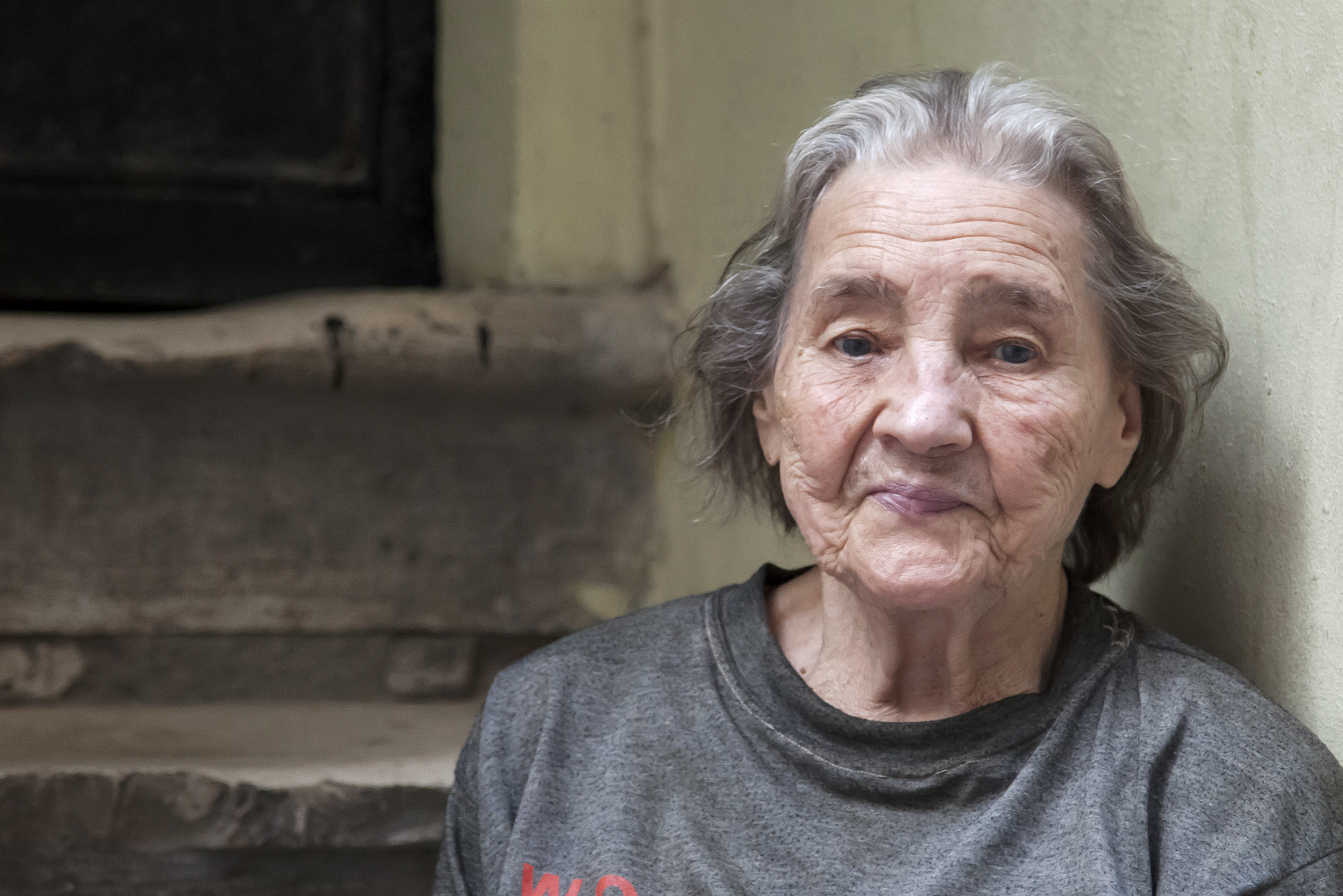 photo of older woman sitting on concrete steps