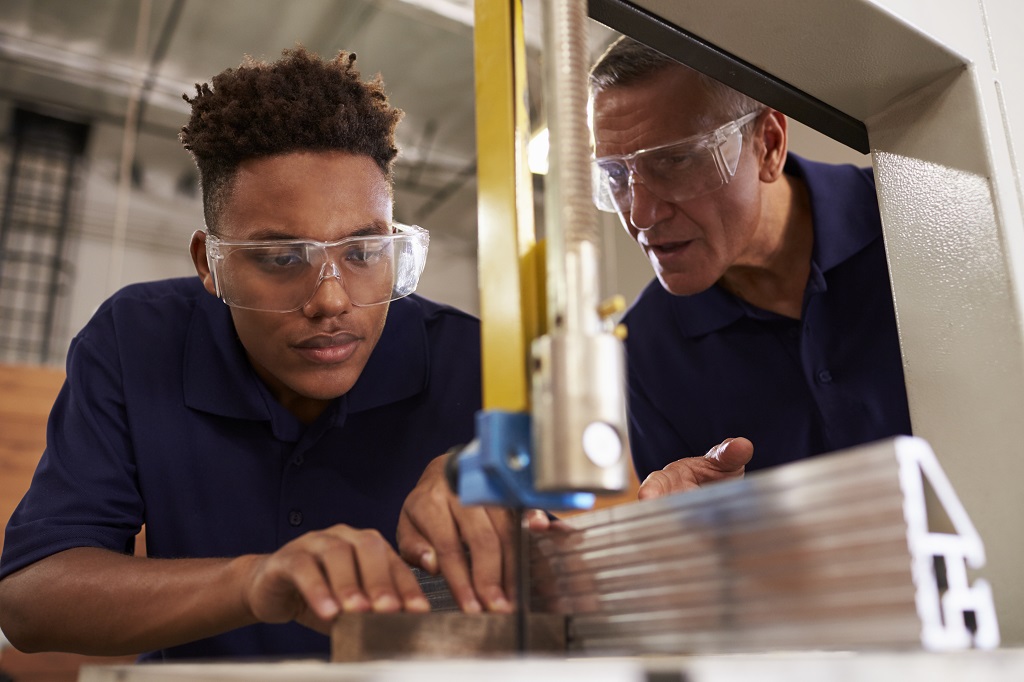 Photo of student in metal shop with instructor